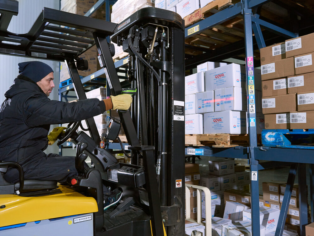 Cariste scanne les cartons avec un lecteur portatif pour le suivi d’inventaire en entrepôt