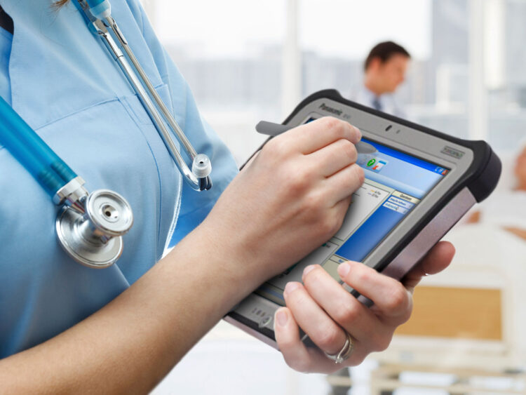 Infirmière documente les données des patients avec une solution logicielle mobile sur tablette à l'hôpital