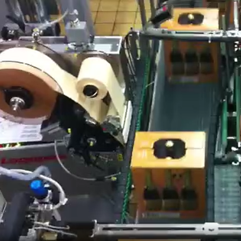 Etikettiermaschine für Getränkekartons an einem Förderband in Verpackungslinie