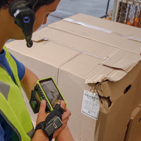 Mitarbeiter mit mobilem Wearable System erfasst Transportschäden und dokumentiert beschädigte Waren im Speditionslager