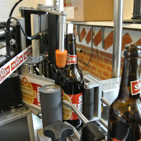 Automatische Etikettieranlage von Logopak klebt Markenetiketten auf Bierflaschen in einer Brauerei