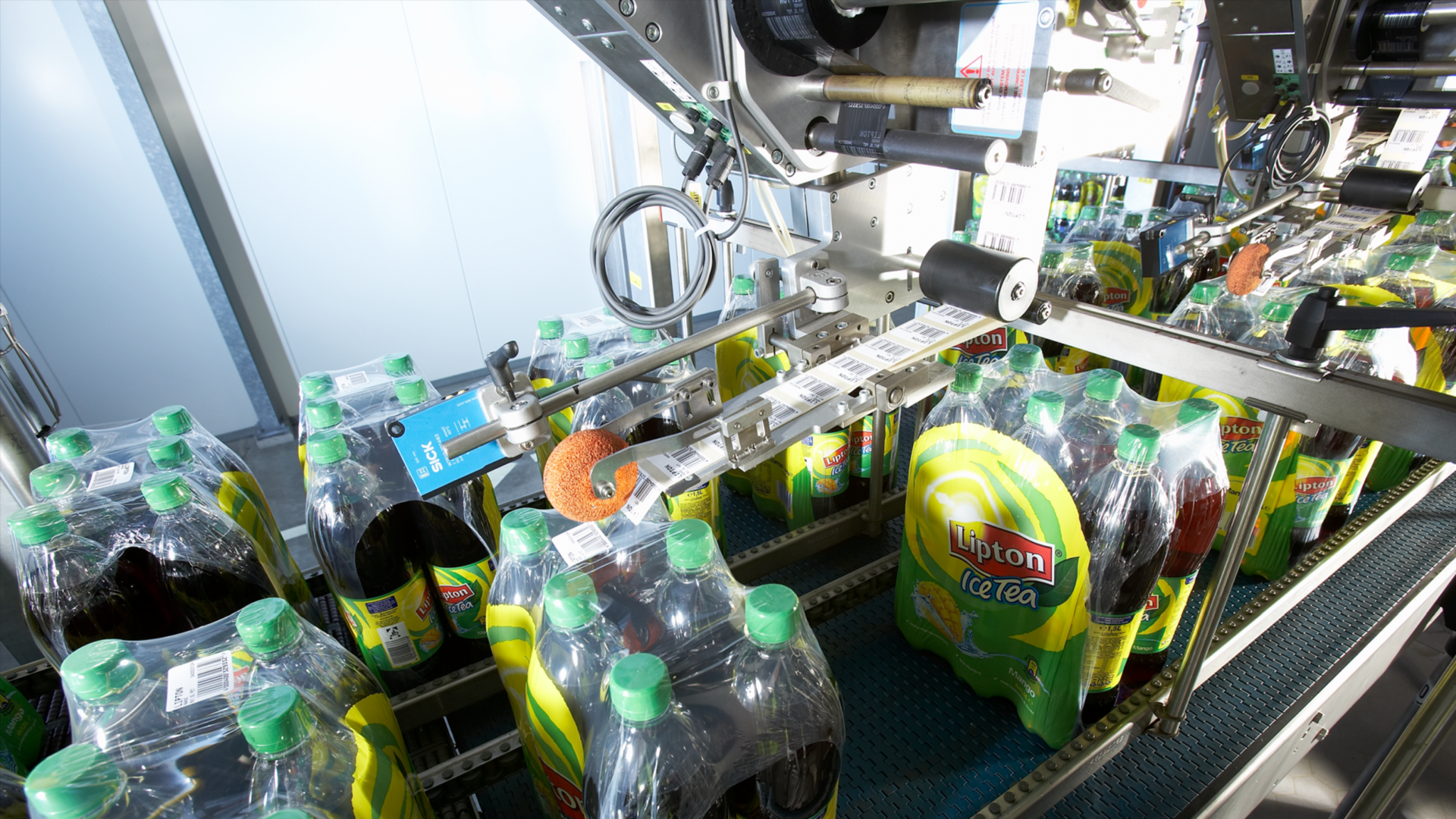 Automatische Etikettieranlage appliziert Barcode-Etiketten auf Multipackungen in der Lebensmittelproduktion und Getränkeindustrie