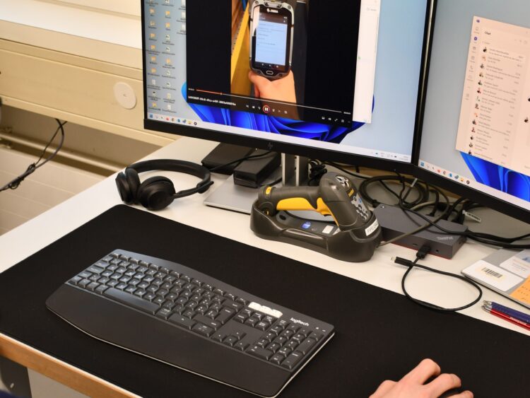 Un technicien de service à sa place de travail au centre de service de mobit aide les clients lors d'une analyse à distance