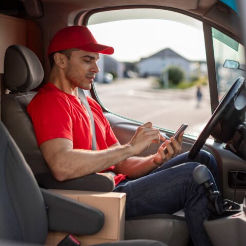 Article de blog de mobit sur PTV Logistics et OptiFlow - un livreur reçoit des informations sur l'itinéraire de livraison et saisit les données des retours sur un terminal mobile